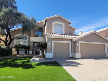 Charming two-story home featuring a well-manicured lawn and a three-car garage at 13566 N 93Rd Pl, Scottsdale, AZ 85260