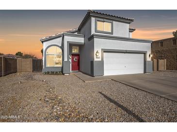 Charming two-story home featuring a red door, gray trim, and a well-maintained front yard at 1447 S Portland Ave, Gilbert, AZ 85296