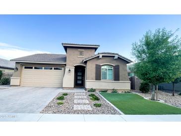 Charming single-story home featuring desert landscaping, a two-car garage, and a welcoming front entry at 20471 E Carriage Way, Queen Creek, AZ 85142