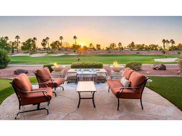 Backyard boasts fire bowls, putting green, waterfall feature, seating area and stunning golf course vista at 22020 N San Ramon Dr, Sun City West, AZ 85375