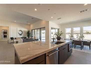 Open-concept kitchen with a large island, modern cabinets, stainless steel appliances, and a seamless transition to the living room at 24066 S 218Th Pl, Queen Creek, AZ 85142