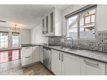 Well-lit kitchen featuring stainless steel appliances, mosaic backsplash, and gray countertops at 324 W Culver St # 2, Phoenix, AZ 85003