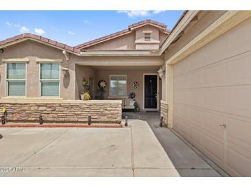 Charming home exterior boasts stone accents, covered porch, and inviting curb appeal, next to the garage at 337 S 172Nd Dr, Goodyear, AZ 85338