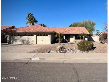 Charming single-story home with a well-manicured front yard and a two-car garage at 8984 E Sutton Dr, Scottsdale, AZ 85260