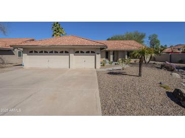 Charming single-story home with a tile roof, two-car garage, and low-maintenance desert landscaping at 8984 E Sutton Dr, Scottsdale, AZ 85260