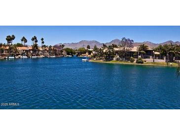 Scenic waterfront view featuring calm water, waterfront homes and a mountain backdrop at 10080 E Mountain View Lake Dr # 138, Scottsdale, AZ 85258
