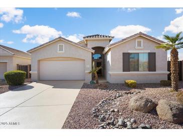 Charming single-story home features a well-manicured front yard and attached two-car garage at 18123 W Hayden Dr, Surprise, AZ 85374