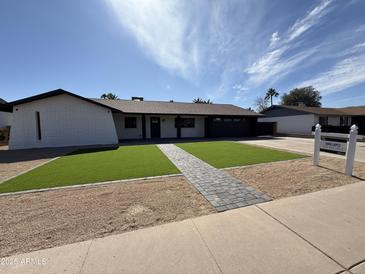 Charming single-story home featuring a well-manicured lawn and a stylish gray brick pathway at 2901 E Cortez St, Phoenix, AZ 85028