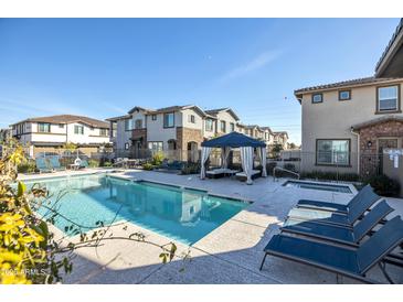 Relaxing community pool area with lounge chairs, a gazebo, and a sparkling pool at 4100 S Pinelake Way # 143, Chandler, AZ 85249