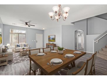 Bright, open-concept living room and dining area with hardwood floors and modern furnishings at 43608 W Kristal Ln, Maricopa, AZ 85138