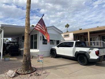 Charming single-Gathering home with a well-maintained yard and a modern white truck in the driveway at 1344 W Inuit Ave, Apache Junction, AZ 85119