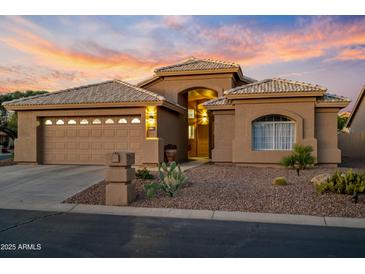 Charming single-story home boasts a two-car garage, desert landscaping and an inviting front entrance at 14728 W Cheery Lynn Dr, Goodyear, AZ 85395