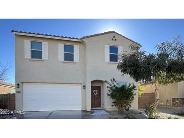 Two-story home with a neutral stucco finish, a two-car garage and a well-kept front yard at 23689 W Watkins St, Buckeye, AZ 85326