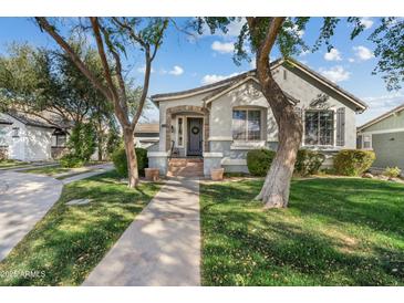 Charming single-story home featuring a well-maintained lawn, mature trees, and a welcoming front entrance at 2626 E Valencia St, Gilbert, AZ 85296