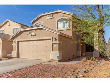 Charming two-story home featuring a tan exterior, desert landscaping, and attached two-car garage at 28549 N Dolomite Ln, San Tan Valley, AZ 85143