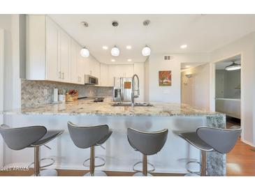 Modern kitchen featuring granite countertops, white cabinets and stainless steel appliances at 4850 E Desert Cove Ave # 333, Scottsdale, AZ 85254