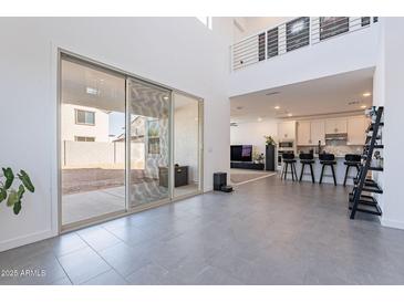 Bright living room features modern gray tile flooring, neutral paint, and access to the kitchen at 5038 W Cheryl Dr, Glendale, AZ 85302