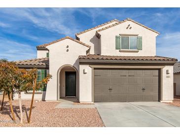 Charming two-story home featuring a stucco exterior, a brown garage door and drought-resistant landscaping at 523 S 201St Ave, Buckeye, AZ 85326