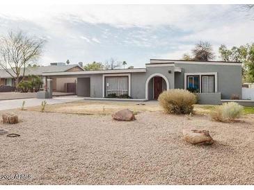 View of a single story home with unique desert landscaping and covered parking at 1111 E Village Circle N Dr, Phoenix, AZ 85022