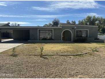 Traditional single story home with a flat roof and desert landscaping at 1111 E Village Circle N Dr, Phoenix, AZ 85022