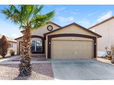 Charming single-story home featuring a two-car garage and desert landscaping with a palm tree at 11609 W Corrine Dr, El Mirage, AZ 85335