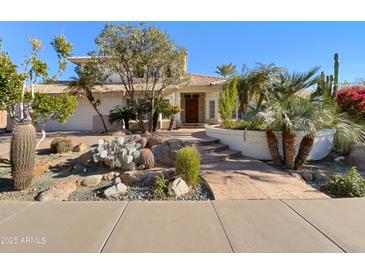 Charming home showcasing a beautiful desert landscape design with various cacti and mature trees at 14645 S 25Th Pl, Phoenix, AZ 85048