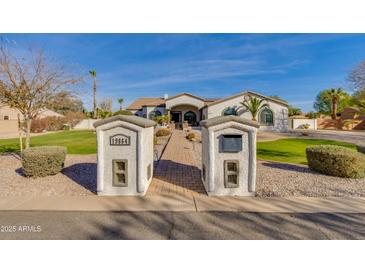 Charming home showcasing a brick walkway, lush green lawn, and distinctive mailbox structures in a well-manicured yard at 19864 E Via Del Oro --, Queen Creek, AZ 85142