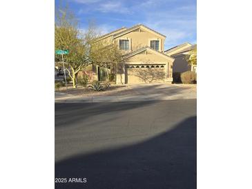 Inviting two-story home featuring a two car garage, manicured landscaping, and charming curb appeal at 21748 W Sonora St, Buckeye, AZ 85326