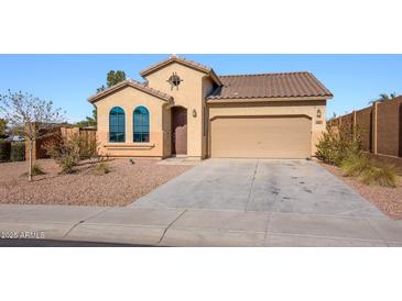 Charming single-story home featuring desert landscaping, a tile roof, and an attached two-car garage at 41124 W Rio Bravo Dr, Maricopa, AZ 85138