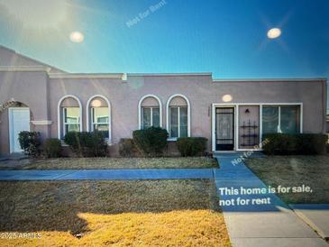 Charming single-story home with arched windows and desert landscaping at 5809 E Thomas Rd, Scottsdale, AZ 85251