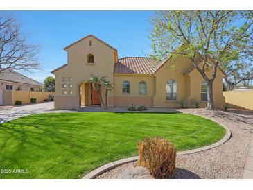 Charming home with lush green lawn, desert landscaping and a tile roof at 2050 N 144Th Dr, Goodyear, AZ 85395