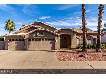 Charming single-story home featuring a three-car garage, desert landscaping, and a tile roof at 21041 N 61St Dr, Glendale, AZ 85308
