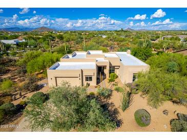 Stunning desert home featuring a flat roof, lush landscaping, and beautiful mountain views at 27467 N 75Th Way, Scottsdale, AZ 85266