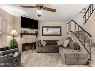 Comfortable living room with a large sectional sofa, fireplace, and staircase at 7977 W Wacker Rd # 171, Peoria, AZ 85381