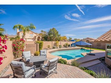 Inviting backyard features a sparkling pool, lounge chairs, and outdoor seating, perfect for relaxing and entertaining at 10490 E Dreyfus E Ave, Scottsdale, AZ 85260