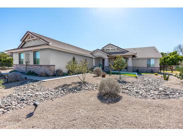 Charming single-story home featuring a desert landscaped front yard, stone accents, and a welcoming facade at 18637 E Flintlock Dr, Queen Creek, AZ 85142