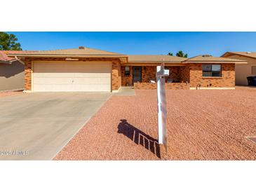 Inviting single-story home featuring a well-maintained brick exterior, a two-car garage, and desert landscaping at 8118 E Medina Ave, Mesa, AZ 85209