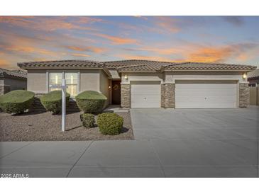 Charming single-story home featuring a three-car garage and a well-manicured front yard at 9952 W Jessie Ln, Peoria, AZ 85383