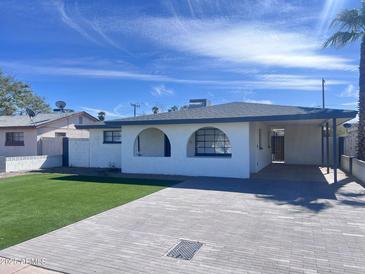 Charming single-story home with a well-maintained lawn and a brick driveway at 2031 E Don Carlos Ave, Tempe, AZ 85281