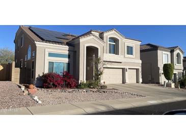 Two-story home with a two car garage, desert landscaping, and solar panels at 25035 N 63Rd Dr, Phoenix, AZ 85083