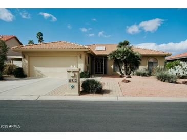 Charming single-story home featuring a well-manicured yard, desert landscaping and an attached two-car garage at 25820 S Saddletree Dr, Sun Lakes, AZ 85248