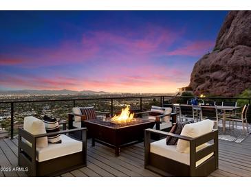 Outdoor deck featuring a cozy firepit and seating area with stunning mountain views and city lights at 4959 E Red Rock Dr, Phoenix, AZ 85018