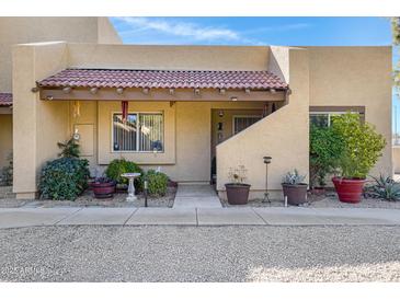 Charming home featuring a red tile roof, cozy front porch, and desert landscaping at 5848 W Gelding Dr, Glendale, AZ 85306