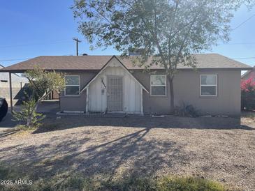 Charming single-story home featuring a cozy front porch and mature trees at 6617 W Peck Dr, Glendale, AZ 85301