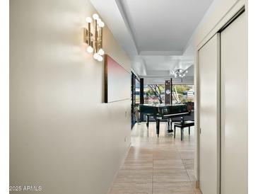 Bright hallway featuring a piano in the background and modern lighting fixture on the wall at 7167 E Rancho Vista Dr # 4006, Scottsdale, AZ 85251