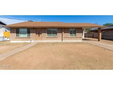 Charming single-story home with a well-maintained brown brick exterior and covered parking at 8816 W Catalina Dr, Phoenix, AZ 85037