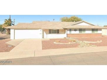 Charming single-story home with a two-car garage, neutral paint, and a well maintained landscape at 11036 N 105Th Ave, Sun City, AZ 85351