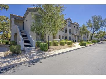 Exterior view of a two-story building with sidewalks and lush landscaping, offering a welcoming curb appeal at 15095 N Thompson Peak Pkwy # 1053, Scottsdale, AZ 85260