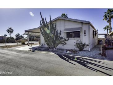Charming single-story home featuring a covered carport and xeriscaped landscaping with a large cactus at 17200 W Bell Rd # 1551, Surprise, AZ 85374