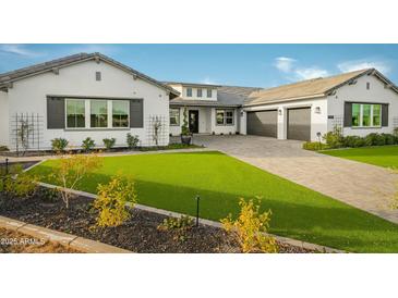Beautiful single-Gathering home featuring a lush lawn, elegant driveway, and a welcoming front entrance at 17801 W Mountainair St, Surprise, AZ 85388
